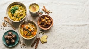 Warming and grounding Vata recipes spread: kitchari, golden milk, stewed apples, root vegetable soup, rice pudding and energy bites