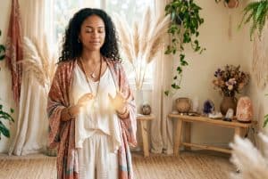 Boho Reiki Master practitioner with hands in a gentle healing gesture and a soft glow